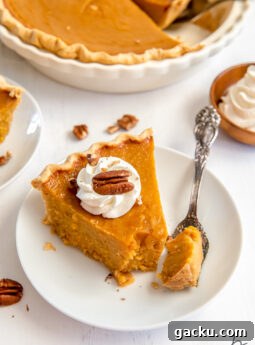 white round plate with slice of sweet potato pie garnished with whipped cream and pecan with fork taking bite