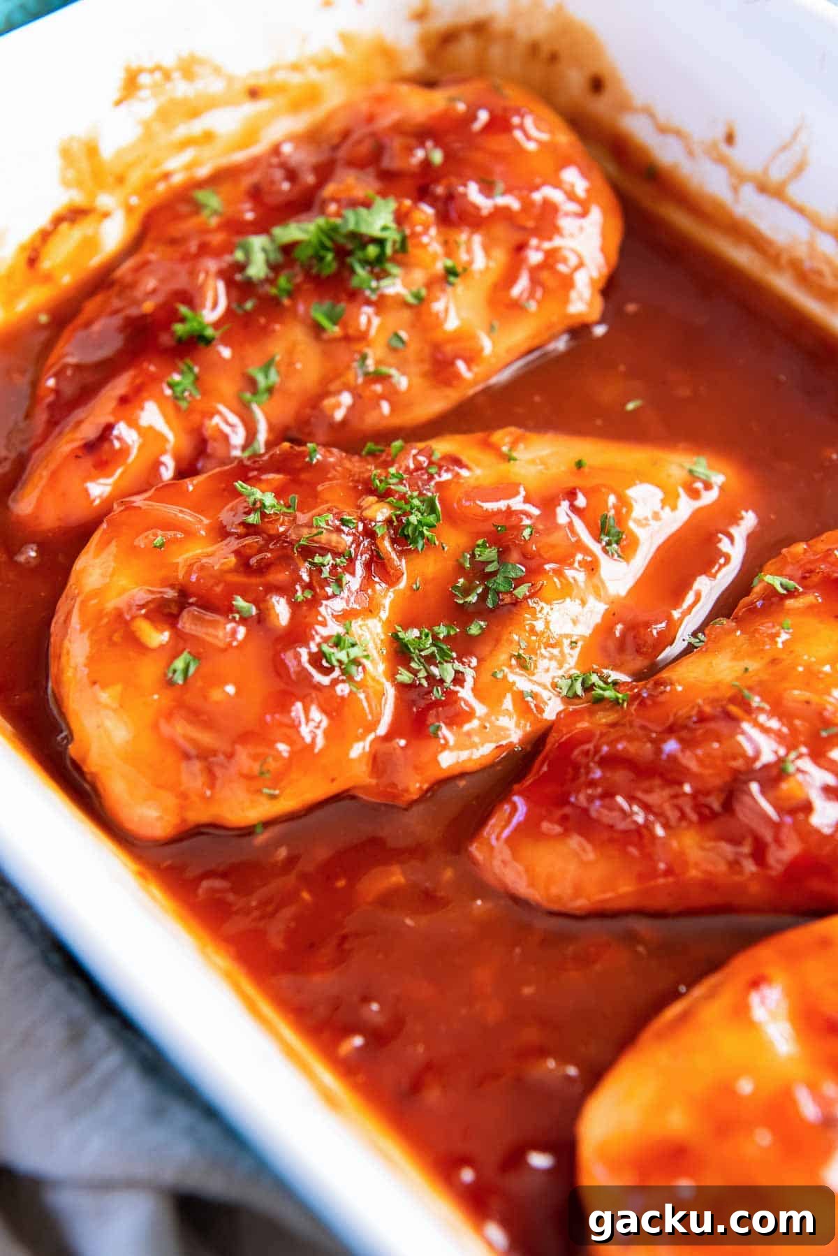 Four pieces of chicken in catalina sauce in a baking dish.