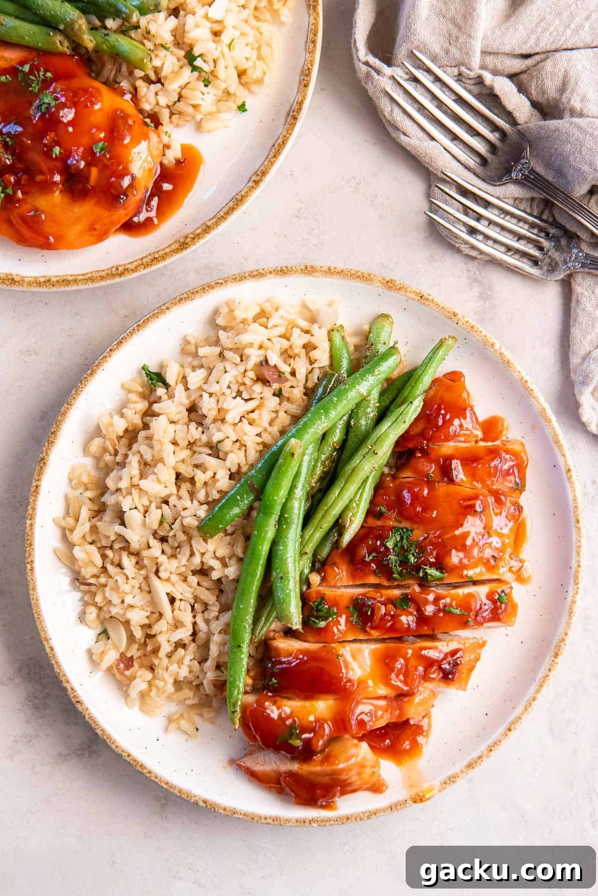 Two dinner plates with catalina chicken, rice, and green beans.