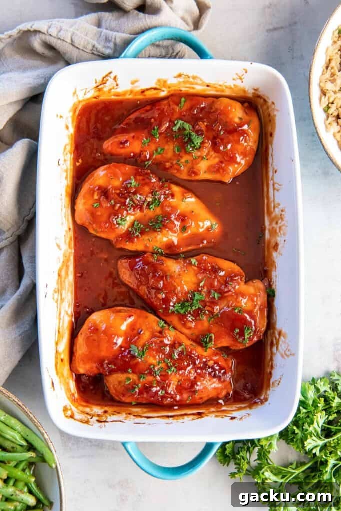 Chicken breasts topped with catalina dressing in a baking dish.