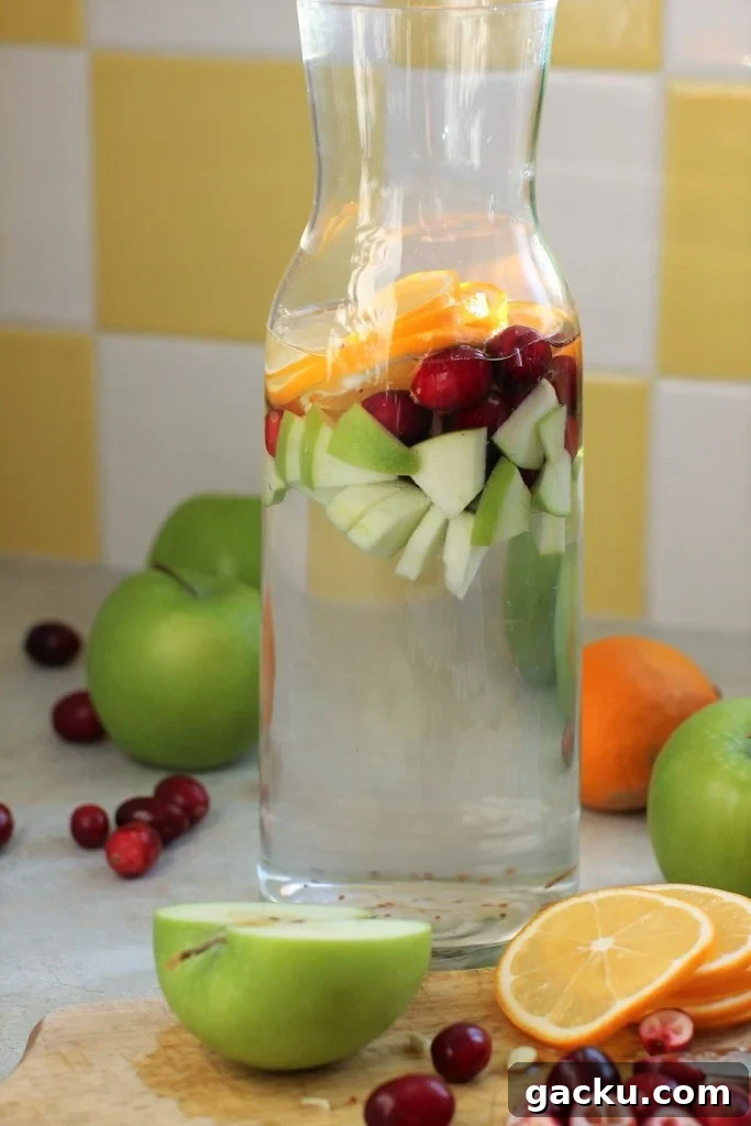 apples, cranberries, lemons in detox water in jug