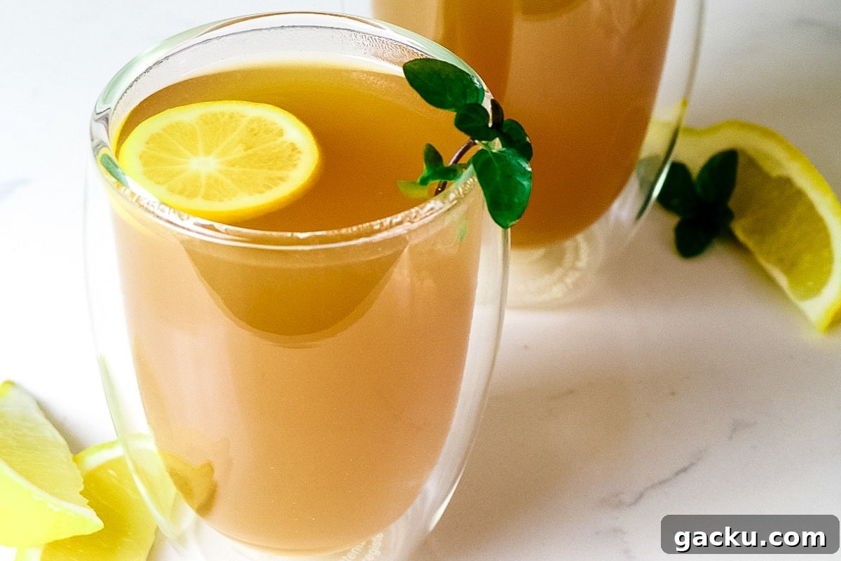 closeup of honey citrus mint tea with peppermint garnish and lemon slice.