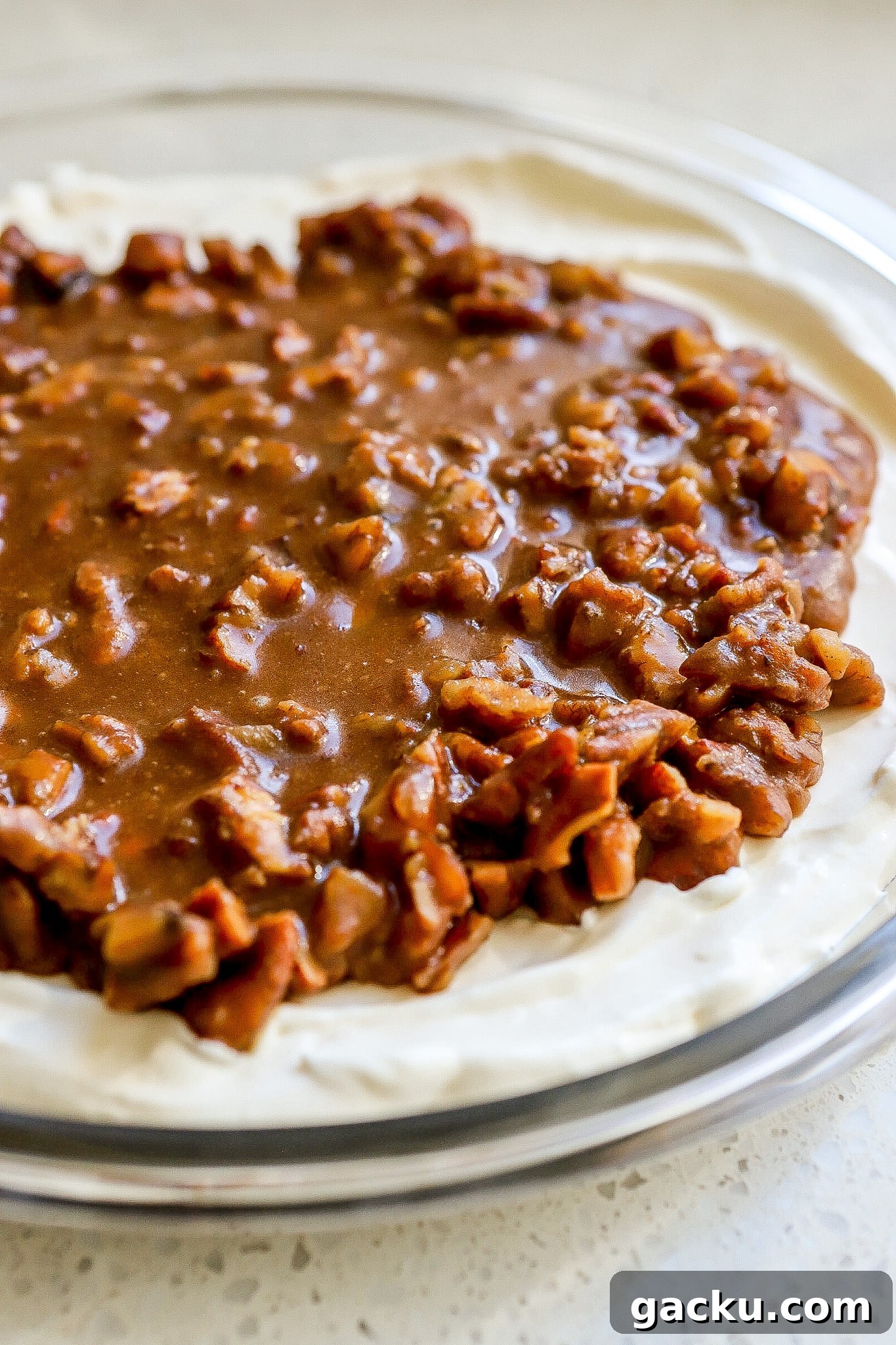 Side view of thanksgiving pecan pie dip in round glass baking dish.