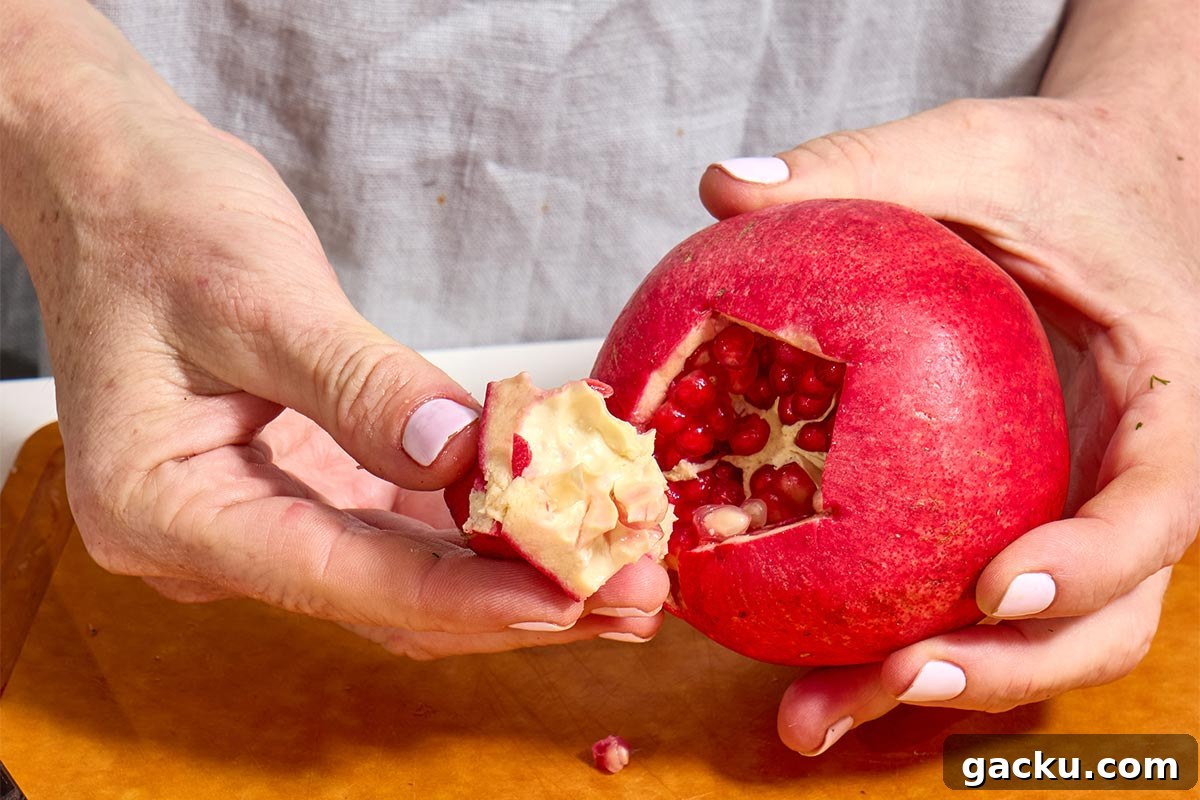 Woman pulling blossom from pomegranate.