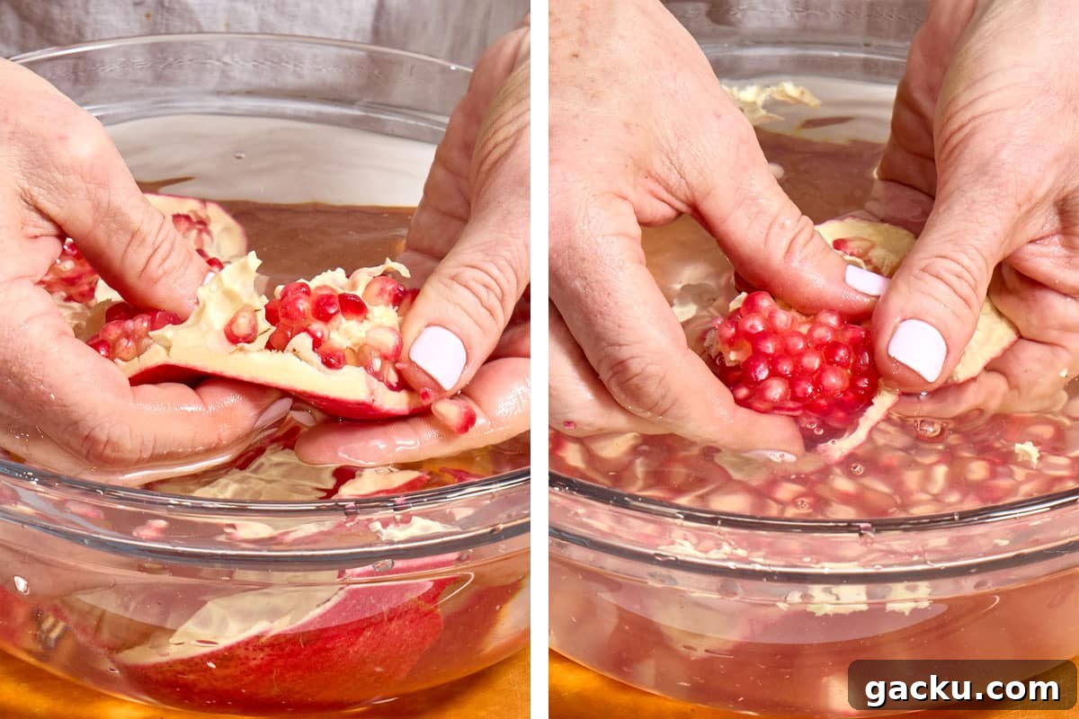 Woman removing pomegranate arils from fruit over bowl of water.