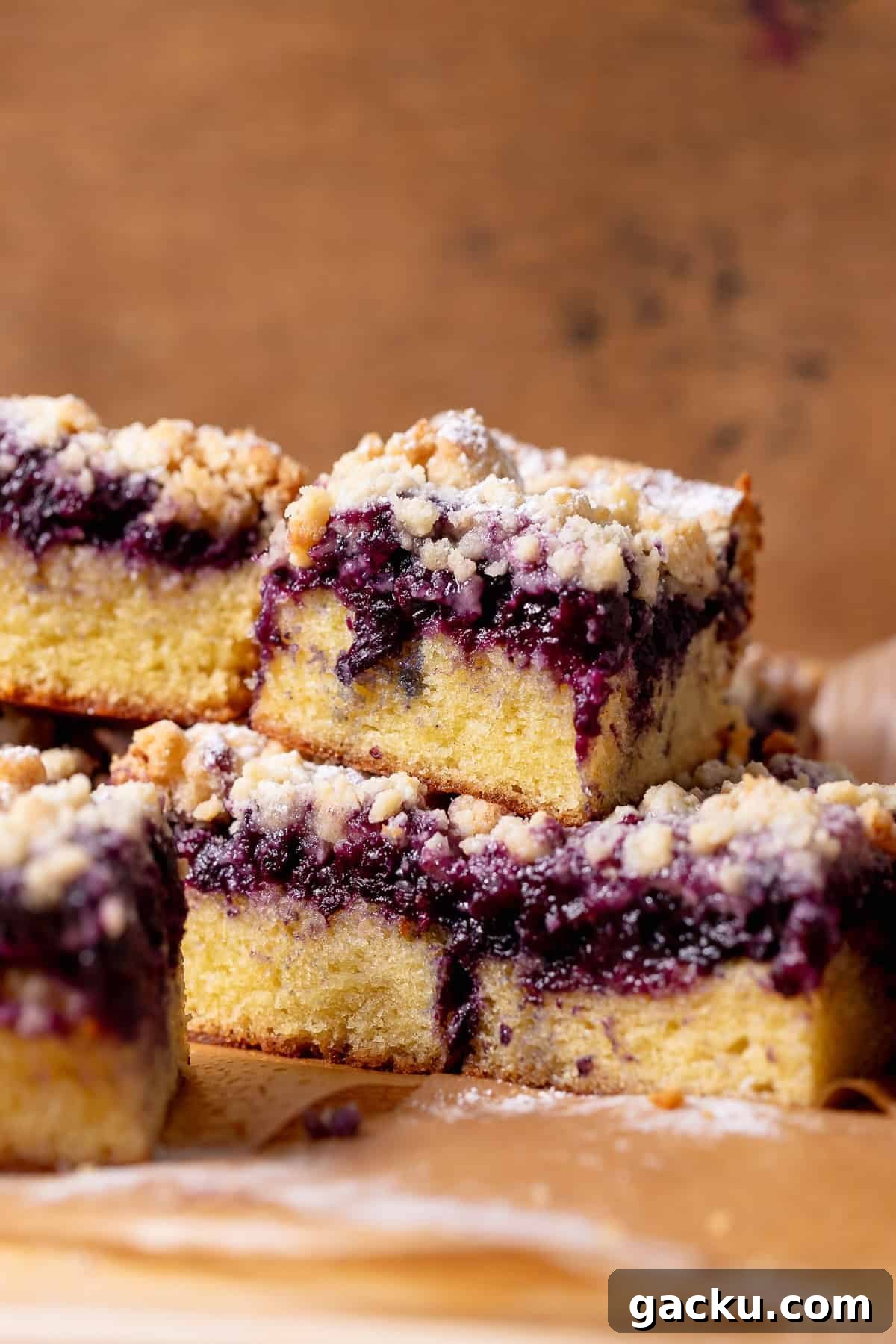 Blueberry Crumb Cake with Buttery Crumble Topping Recipe 2 Stacked blueberry crumb cake slices with a thick blueberry layer and buttery crumb topping.