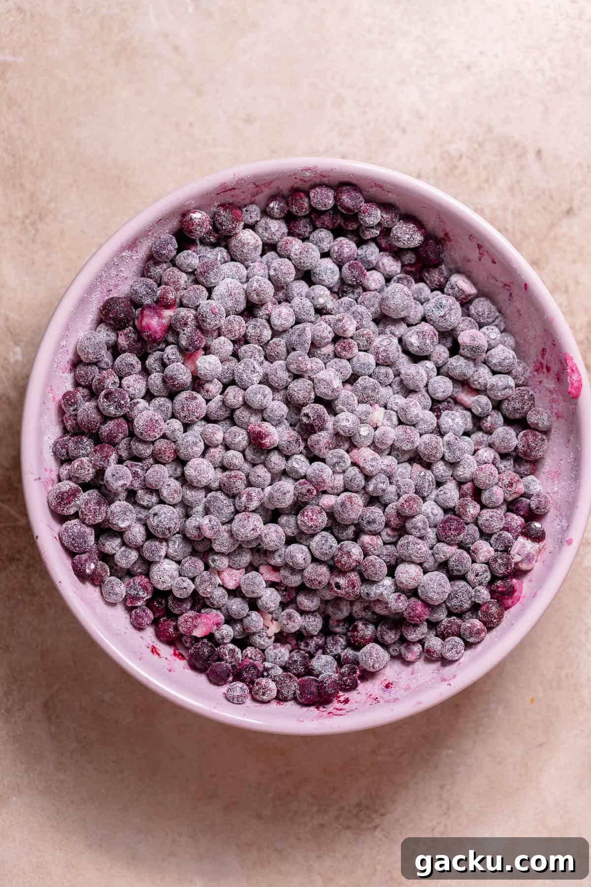 Blueberry Crumb Cake with Buttery Crumble Topping Recipe 3 Frozen blueberries coated in flour in a bowl.
