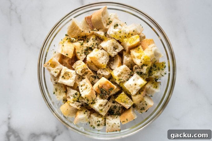 Crispy Homemade Croutons Recipe for Salads & Soups 5 Olive oil, butter, and seasoning drizzled on bread cubes.