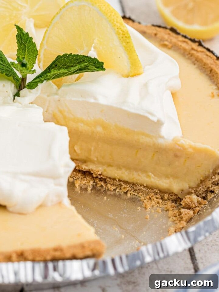 Square cropped shot of the inside of a southern lemon pie with some cream and lemon slices on top.