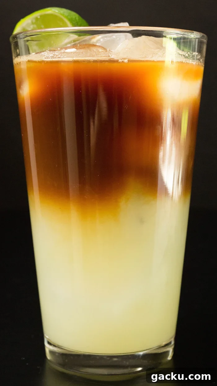 A layered coffee drink with lime juice mixture on the bottom and espresso on top.