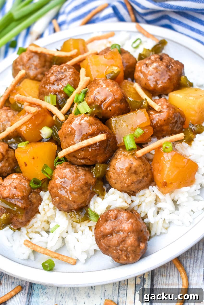 crockpot hawaiian meatballs over steamed white rice on a white dinner plate