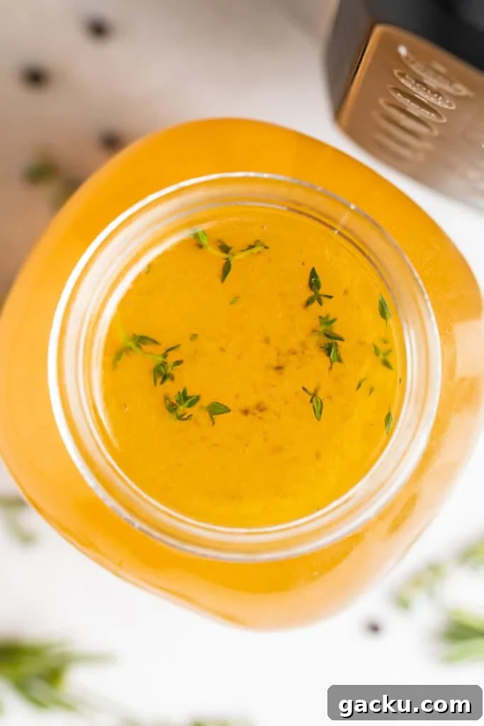 overhead image of instant pot turkey stock with fresh herbs on the side