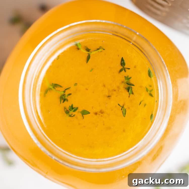 overhead image of instant pot turkey stock with fresh herbs on the side