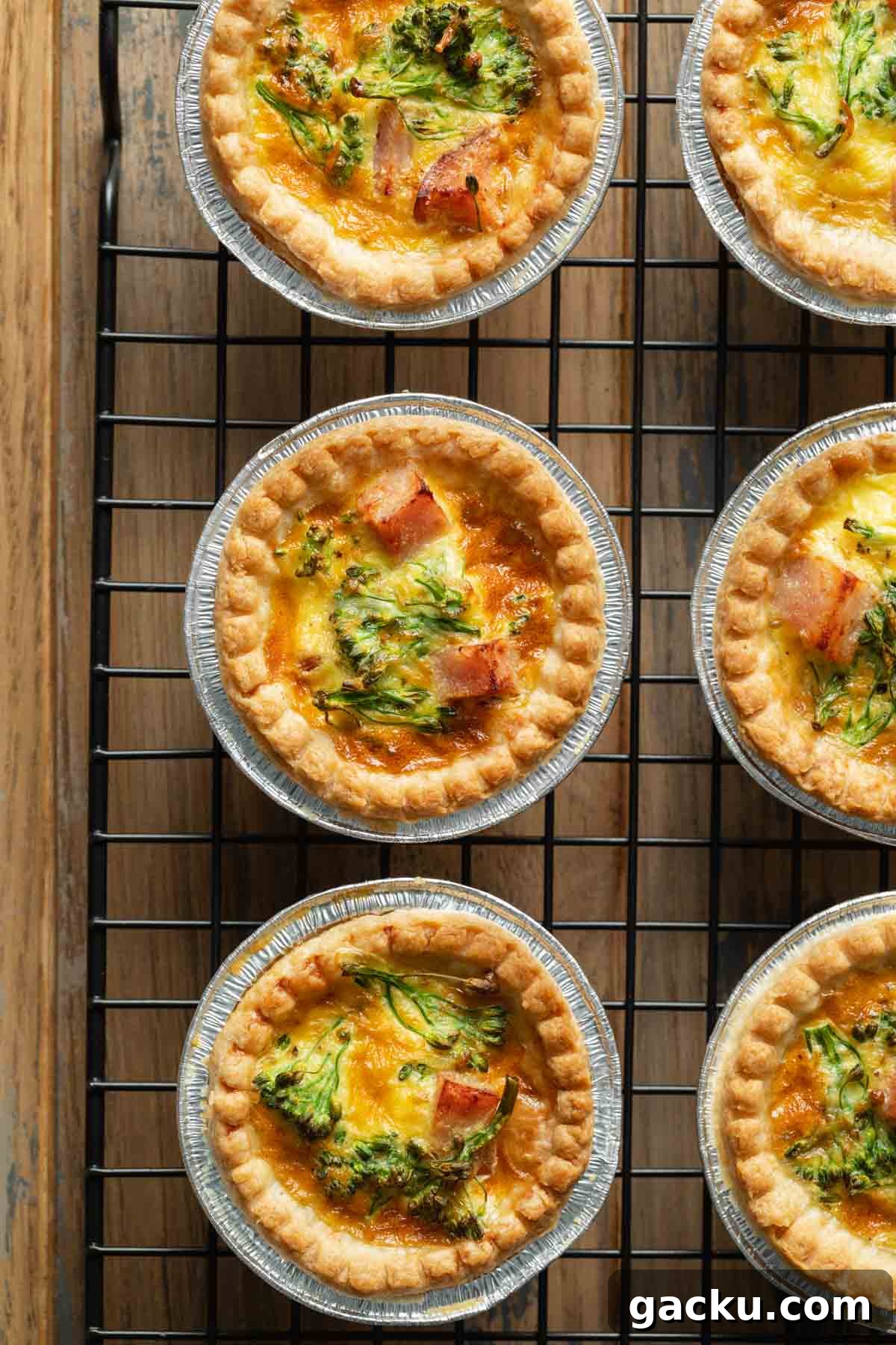 Close up of mini quiches arranged on a wire rack.