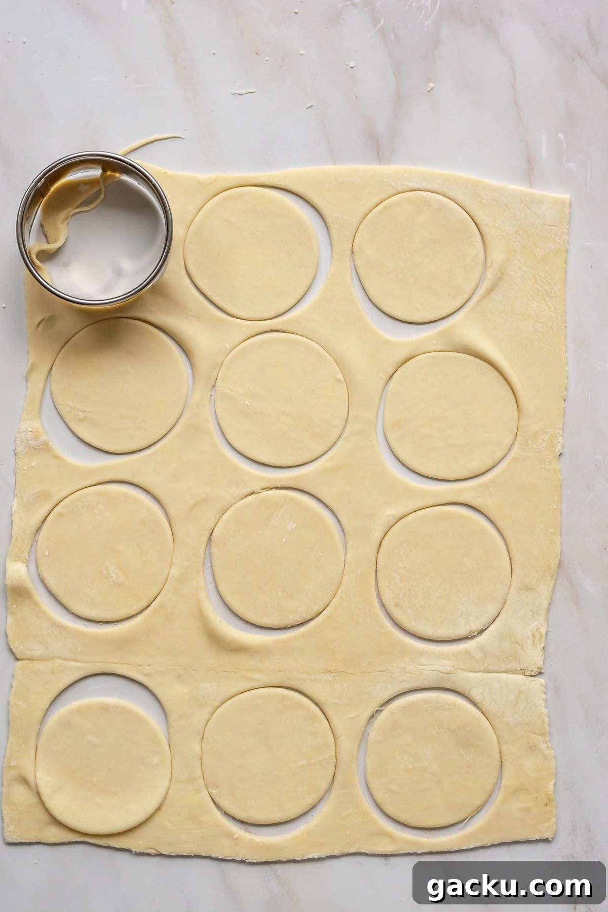 Mini Cheese Tartlets Recipe: Crispy Crusts with Creamy Filling 7 A biscuit cutter cuts out rounds of puff pastry.