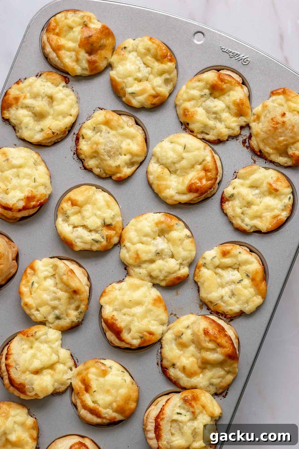 Mini Cheese Tartlets Recipe: Crispy Crusts with Creamy Filling 10 Puffed up, baked cheese tartlets in a muffin tin.