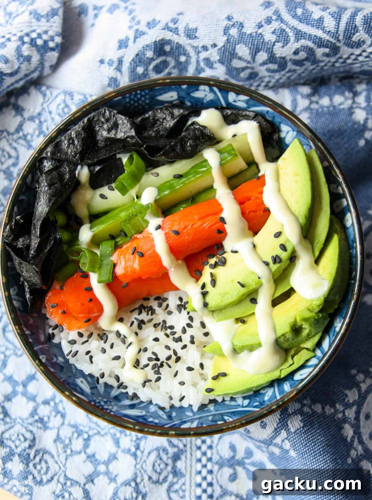 Salmon Chirashi Sushi Bowl Recipe: Easy Homemade Salmon Donburi 2 A sushi bowl with salmon, cucumber, avocado and seaweed.