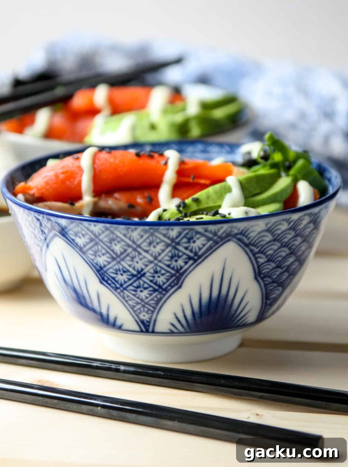 Salmon Chirashi Sushi Bowl Recipe: Easy Homemade Salmon Donburi 3 A blue and white bowl of rice and sushi ingredients.