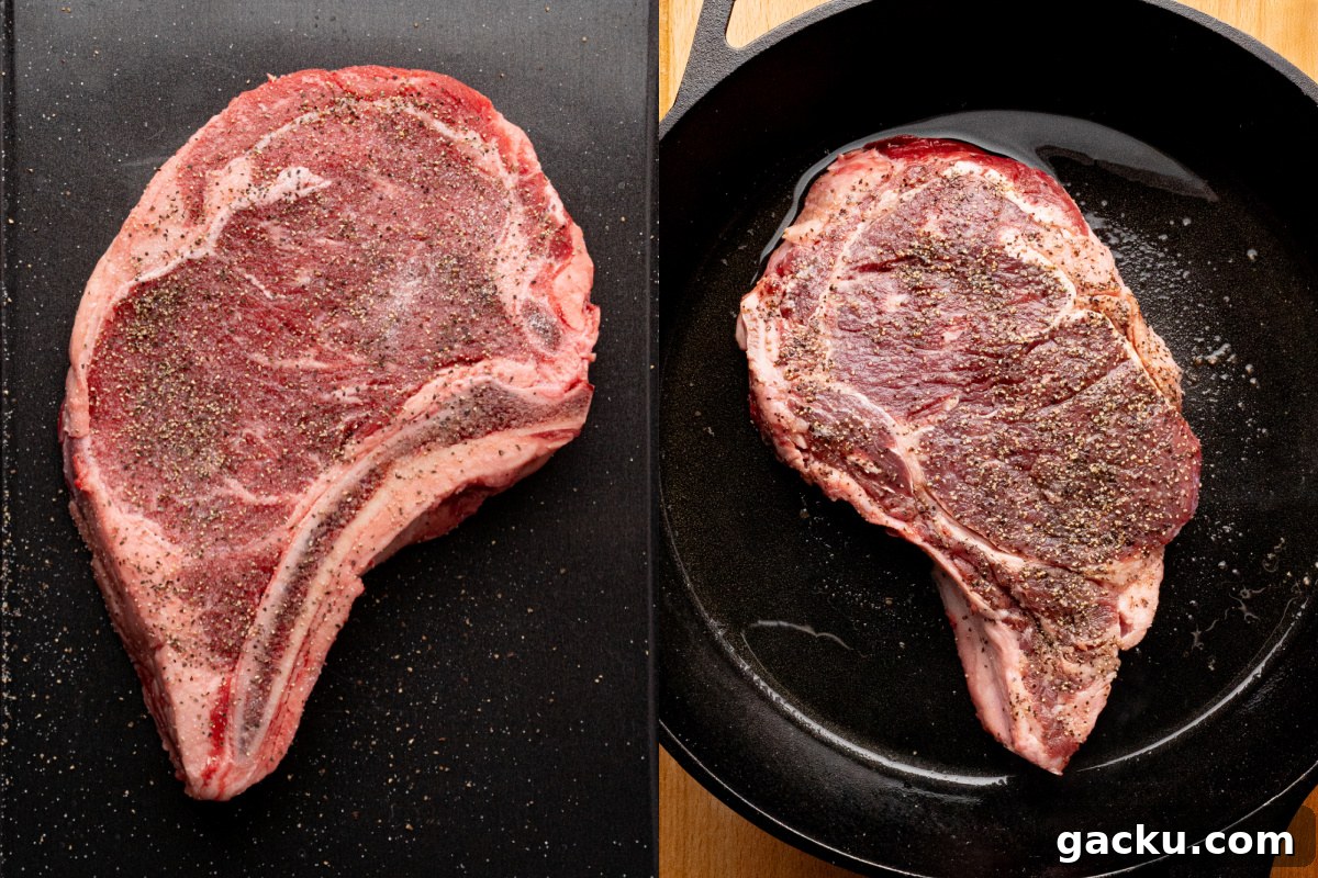 A ribeye steak in a skillet with hot oil and seasoned with salt and pepper.