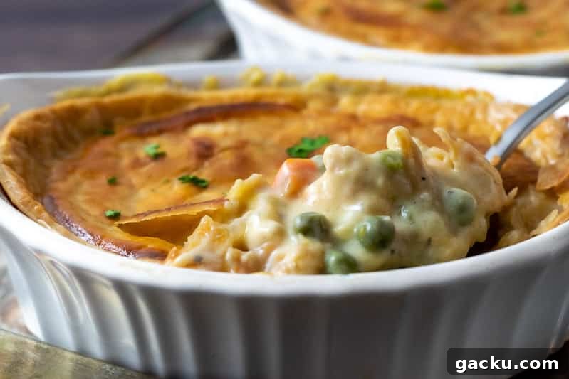 Ultimate Creamy Chicken Pot Pie Recipe for Comforting Weeknight Meals 8 chicken pot pie with spoon lifting some out.