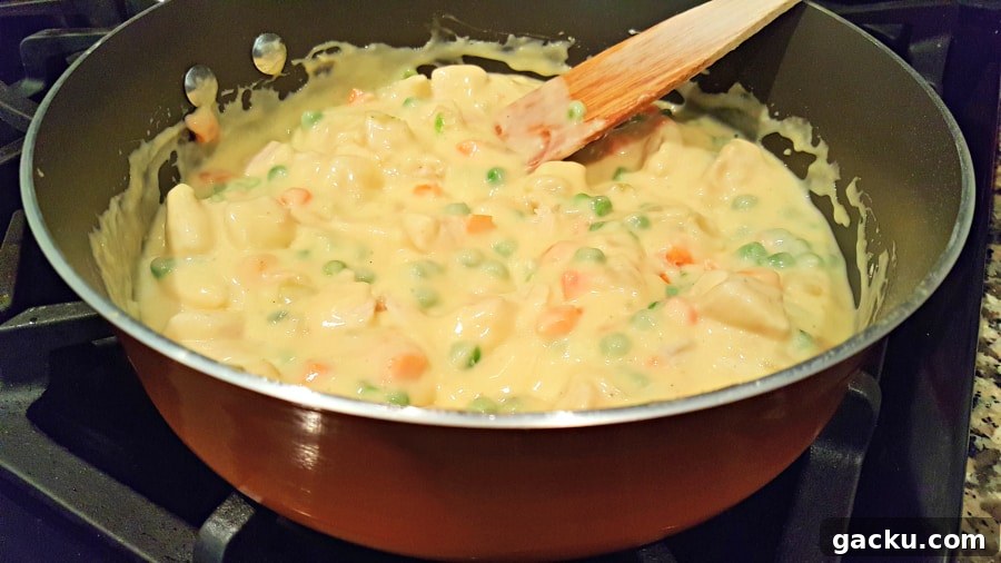 Ultimate Creamy Chicken Pot Pie Recipe for Comforting Weeknight Meals 4 Chicken Pot Pie filling cooking in a pan.