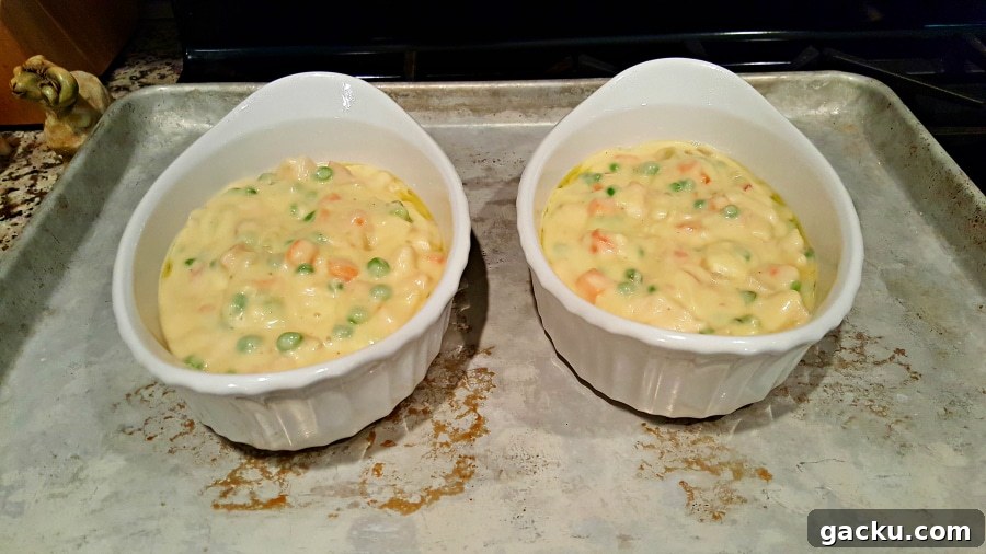 Ultimate Creamy Chicken Pot Pie Recipe for Comforting Weeknight Meals 5 Individual Chicken Pot Pie mixture in baking dishes.