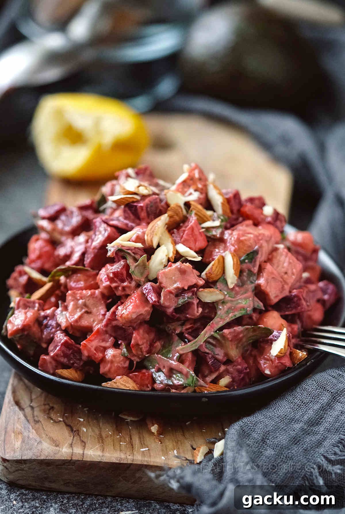 Chicken beet salad tossed with a creamy avocado dressing, served on a plate.