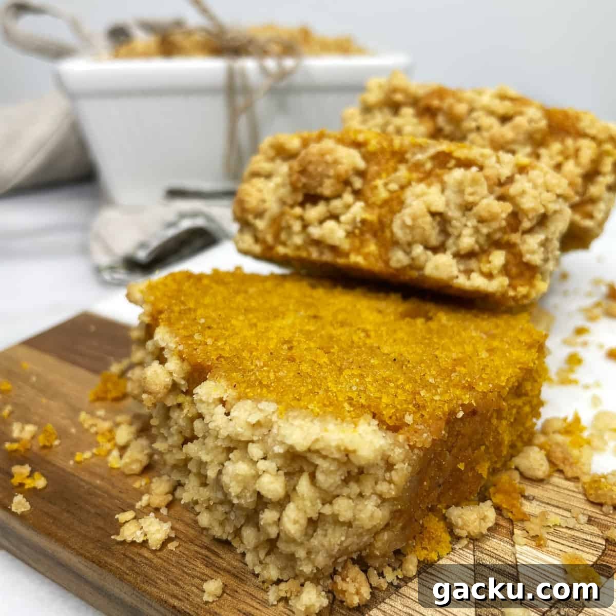 Pumpkin Streusel Quick Bread Recipe for Fall Baking 2 Sliced mini pumpkin loaves on a wooden board.
