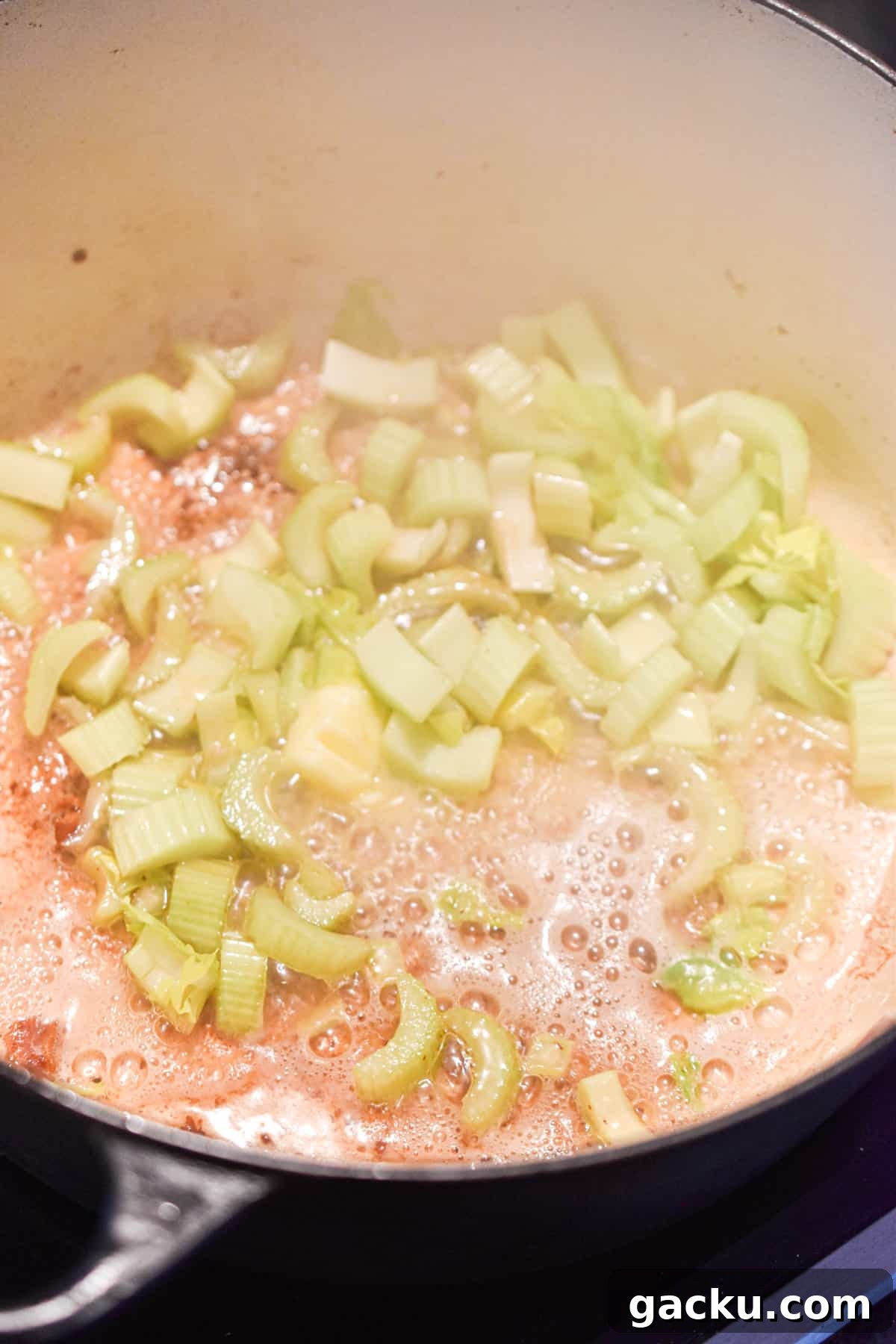 The celery and onions are added to the Dutch oven.