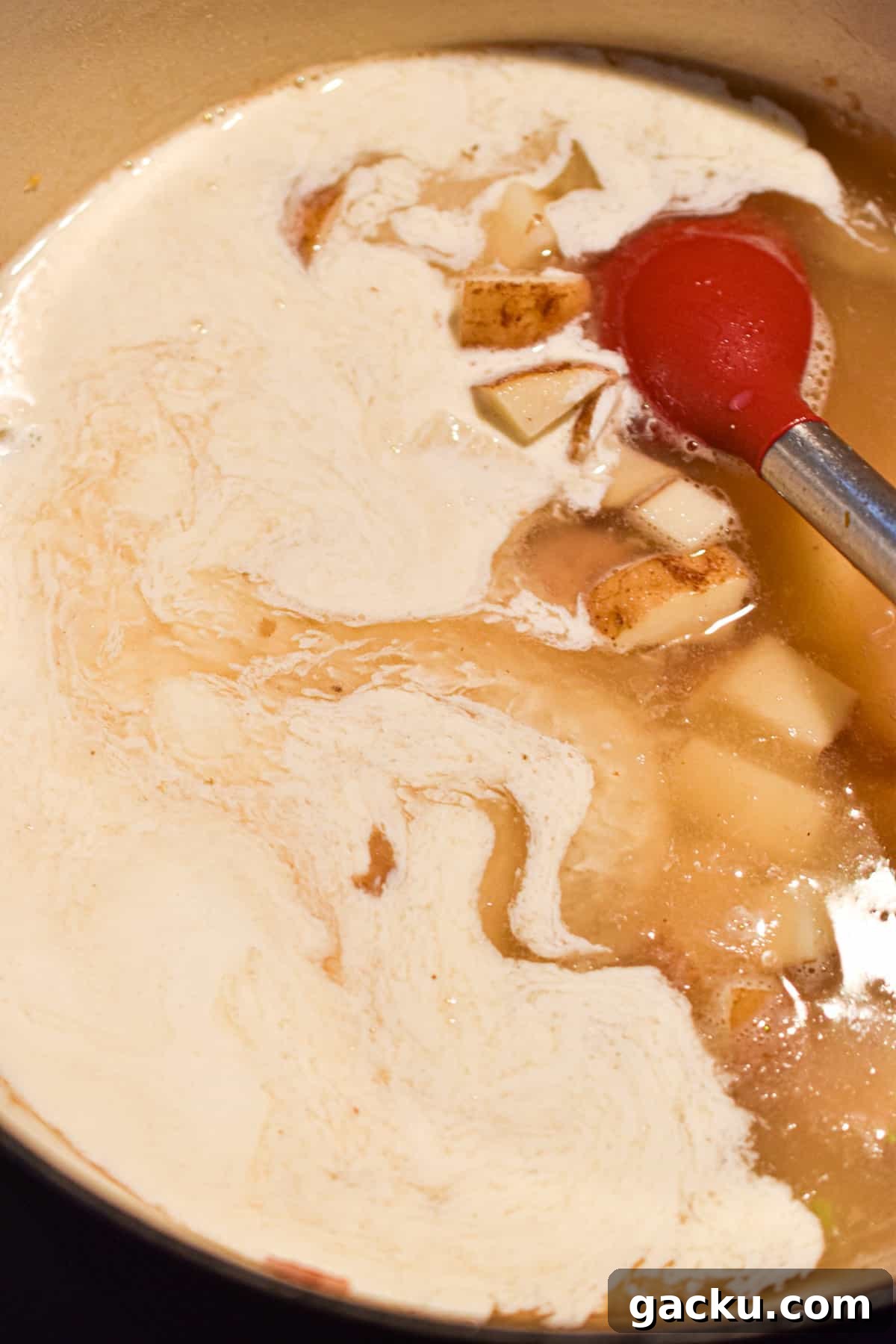 The milk and broth are mixed into the Dutch oven.