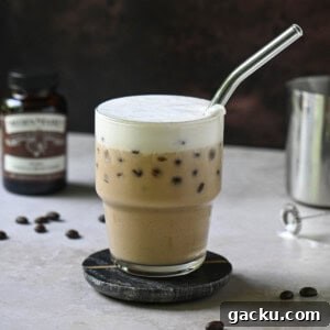 Eye-level view of a vanilla bean latte on a brown surface.