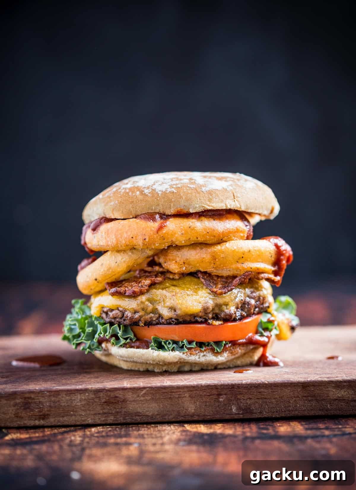 Western Burger with Beer Battered Onion Rings on a wood board.