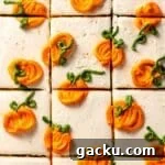 Sliced cake frosted with white frosting and piped mini pumpkins