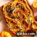 Pumpkin infused butter spread on a board with sage leaves and mini pumpkins