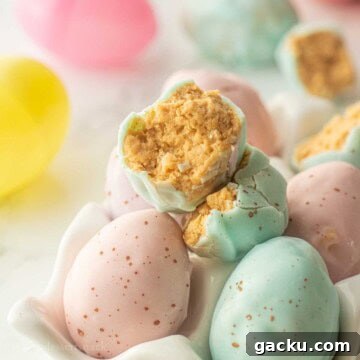 Half of a chocolate dipped peanut butter easter egg in egg carton.