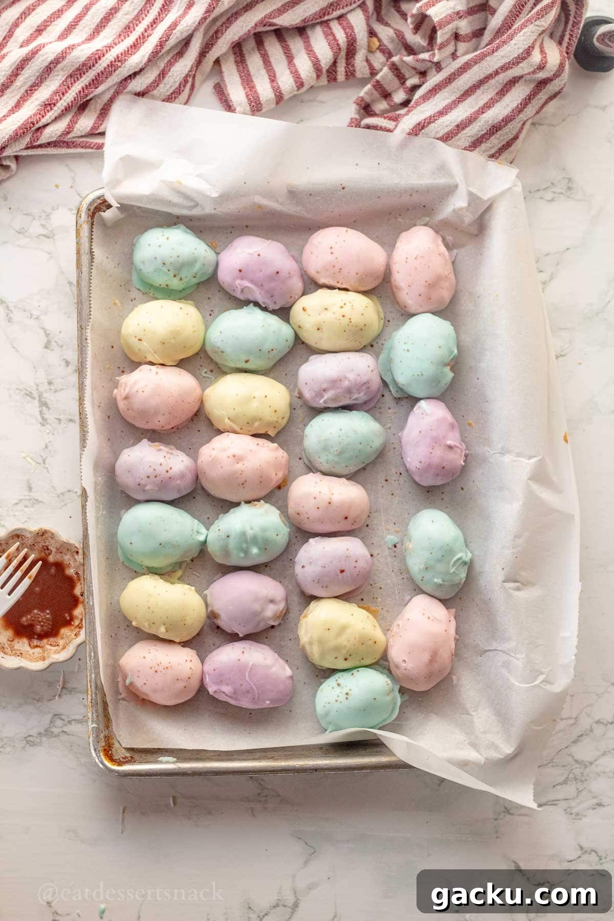 Chocolate dipped peanut butter eggs on parchment paper.