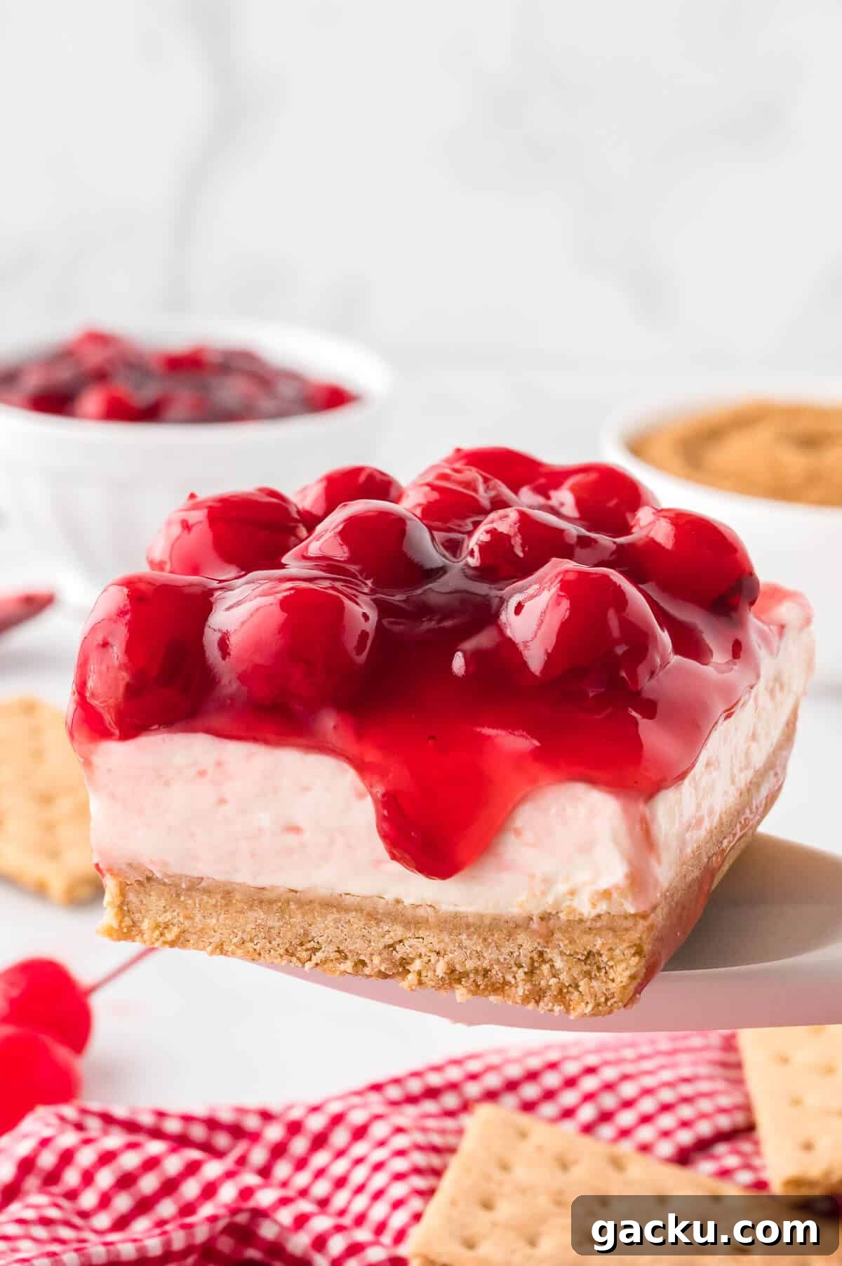 A slice of cherry cheesecake on a serving spoon.