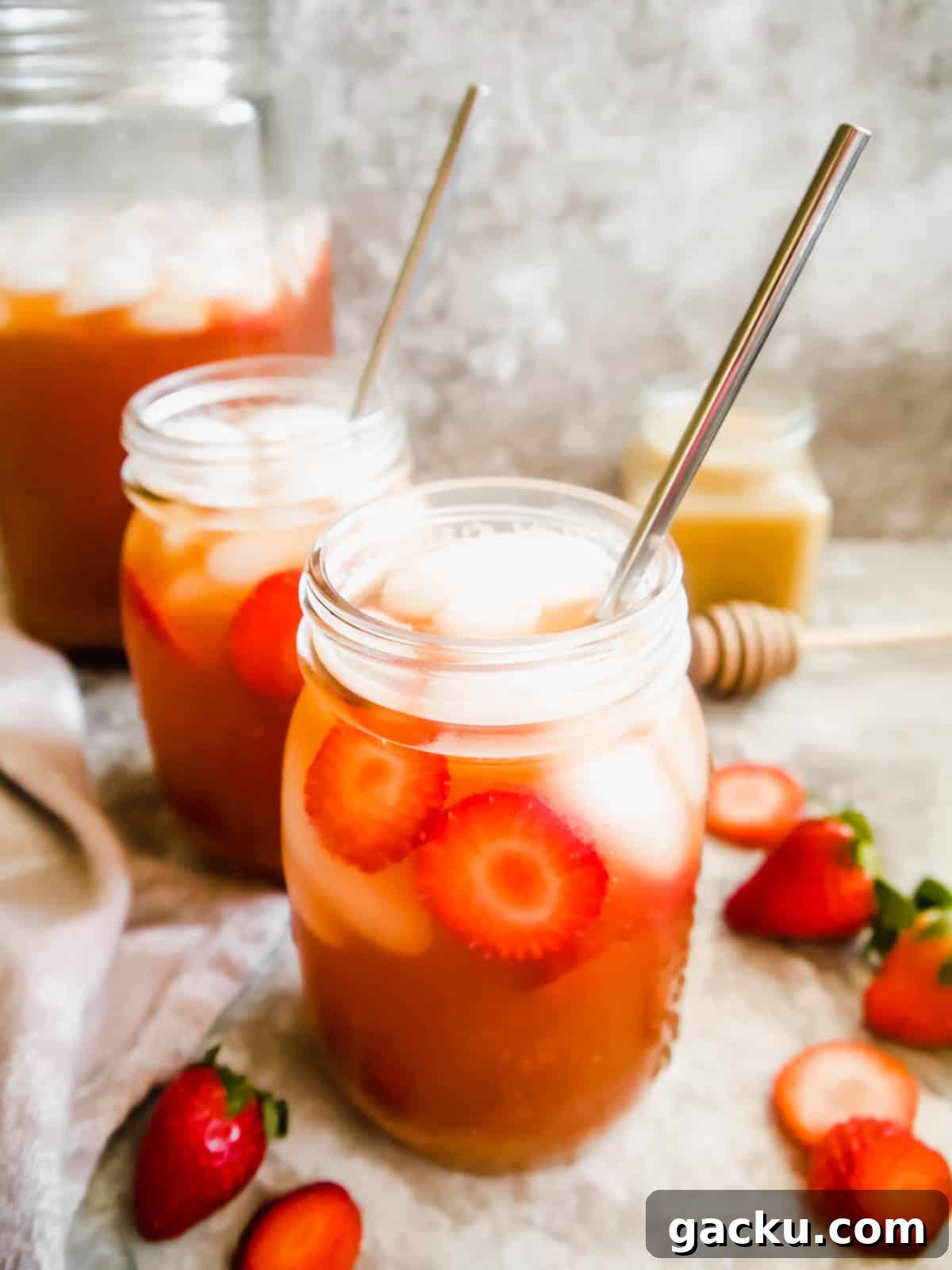 Refreshing Strawberry Iced Tea Recipe: Cool Summer Drink 10 Strawberry Sweet Iced Tea in mason jars with strawberries in them.