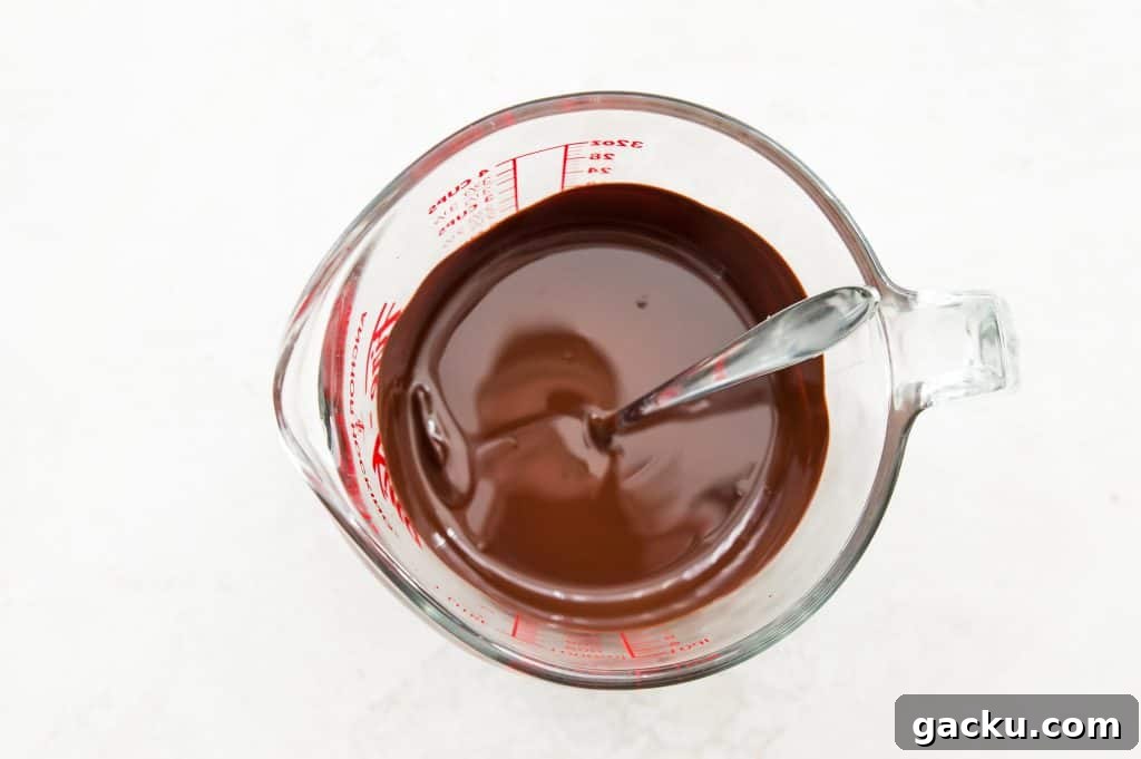 A glass measuring cup with melted chocolate in it.