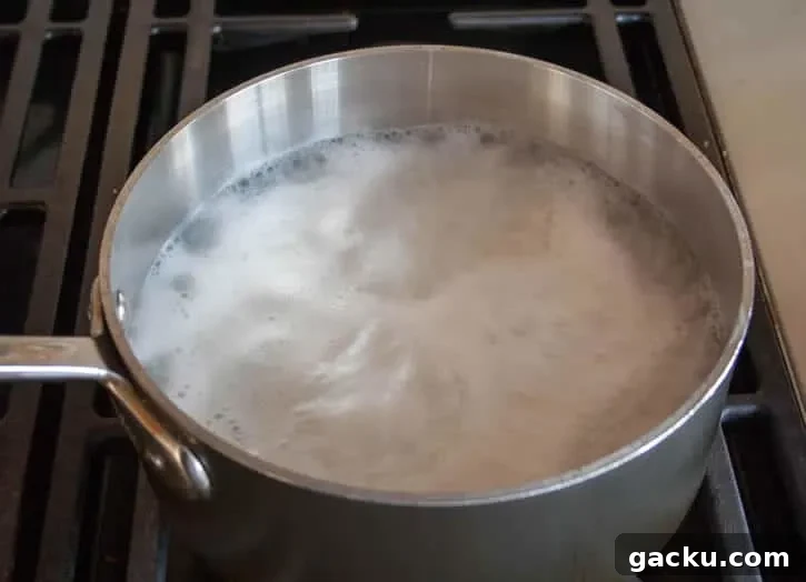 How to Cook Fluffy White Rice Every Time 7 Perfect White Rice boiling in a pot from themerchantbaker.com