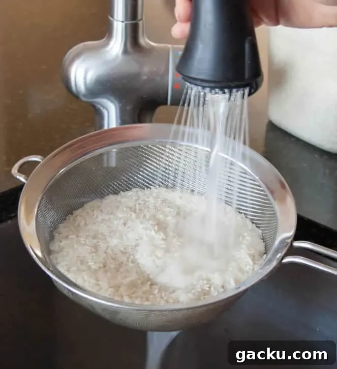 How to Cook Fluffy White Rice Every Time 5 Rinsing Perfect White Rice in a strainer from themerchantbaker.com