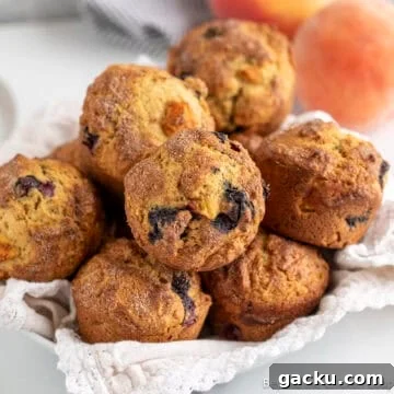 A basket filled with blueberry peach muffins.