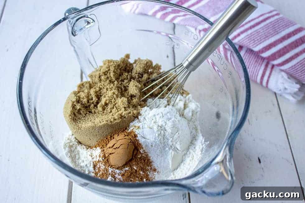 Juicy Peach Muffin Recipe for Perfect Summer Breakfast 5 A bowl with flour, cinnamon and brown sugar with a wire whisk in the bowl.