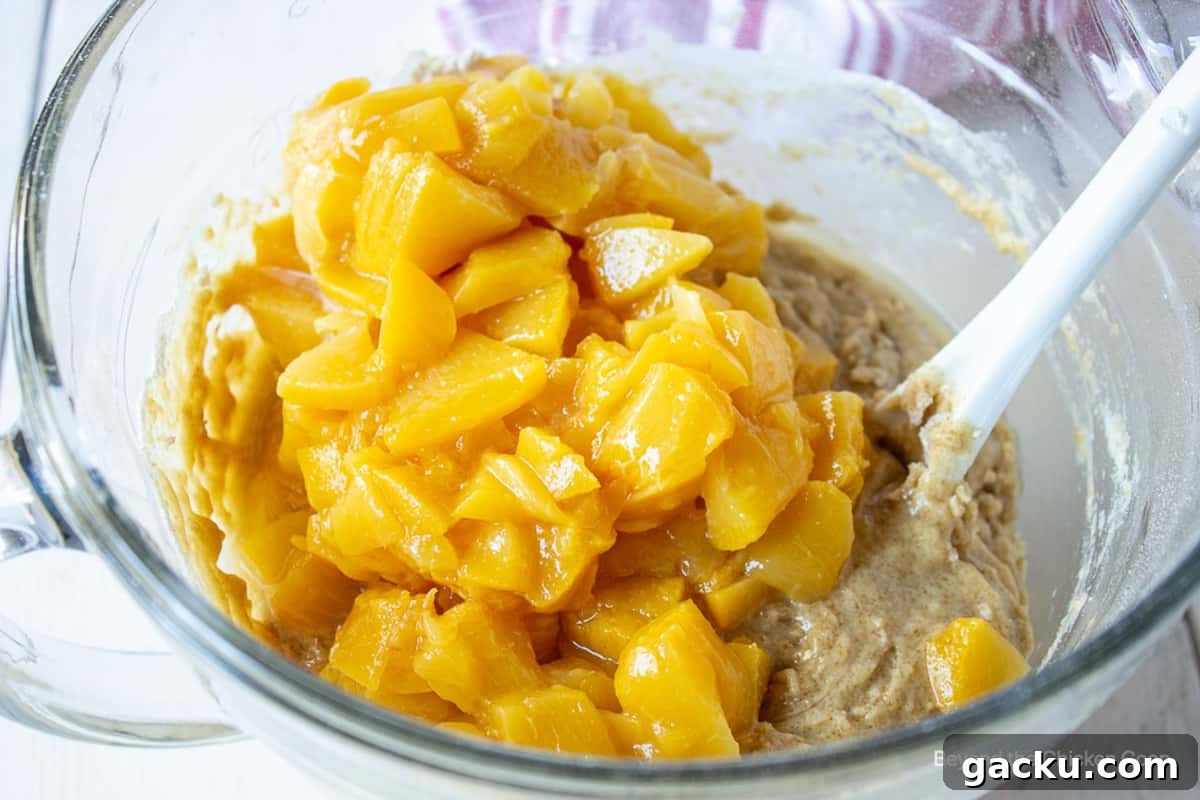 Juicy Peach Muffin Recipe for Perfect Summer Breakfast 8 Chopped peaches in a large glass bowl.