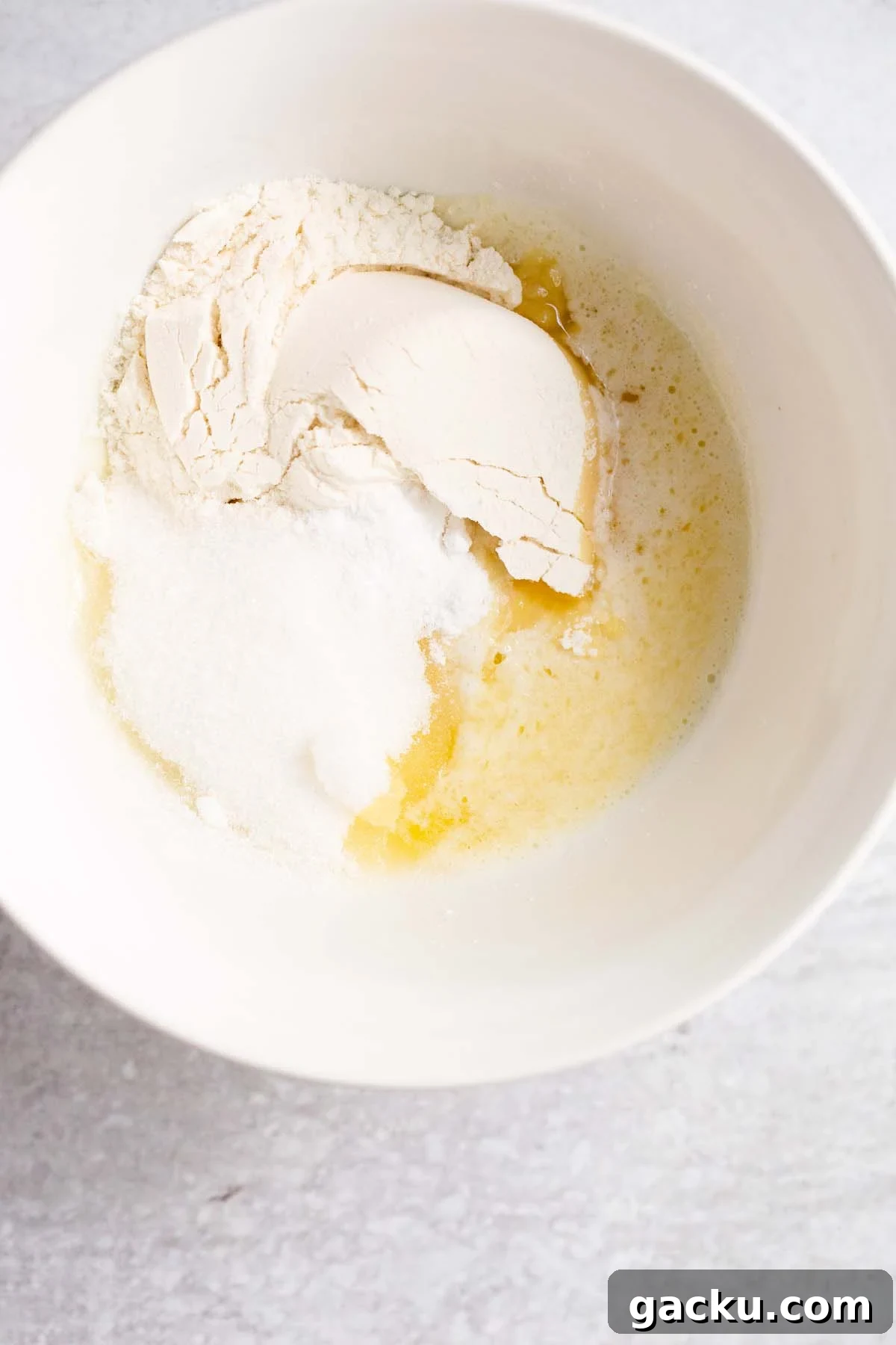 Flour, sugar, and melted butter in a bowl.