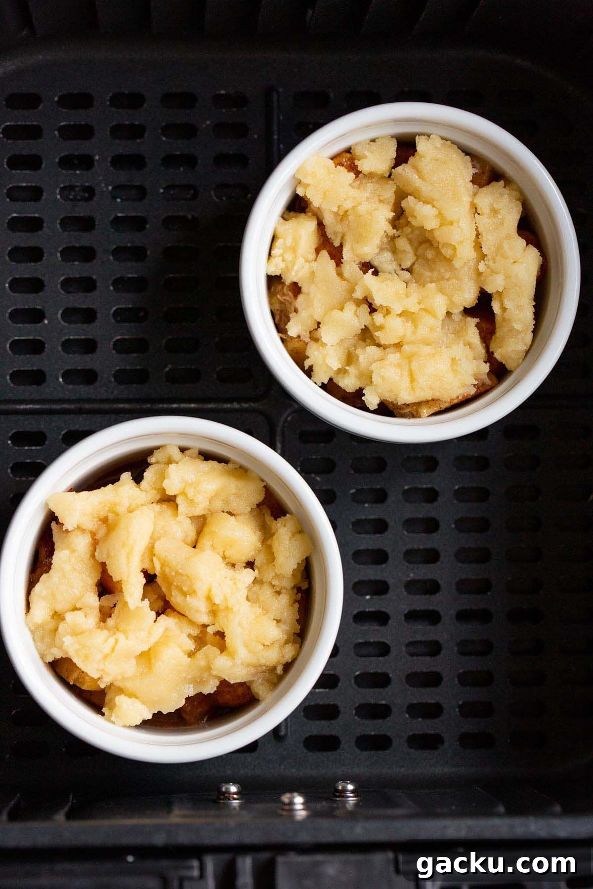 Uncooked peach cobbler in air fryer basket.