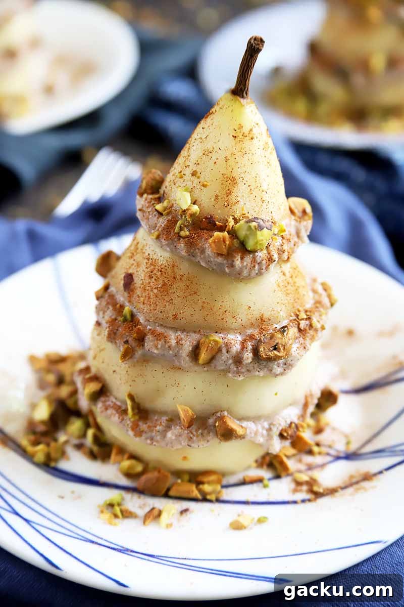 Vertical image of a peeled and sliced whole pear with a spiced filling covered in nuts in between each layer.