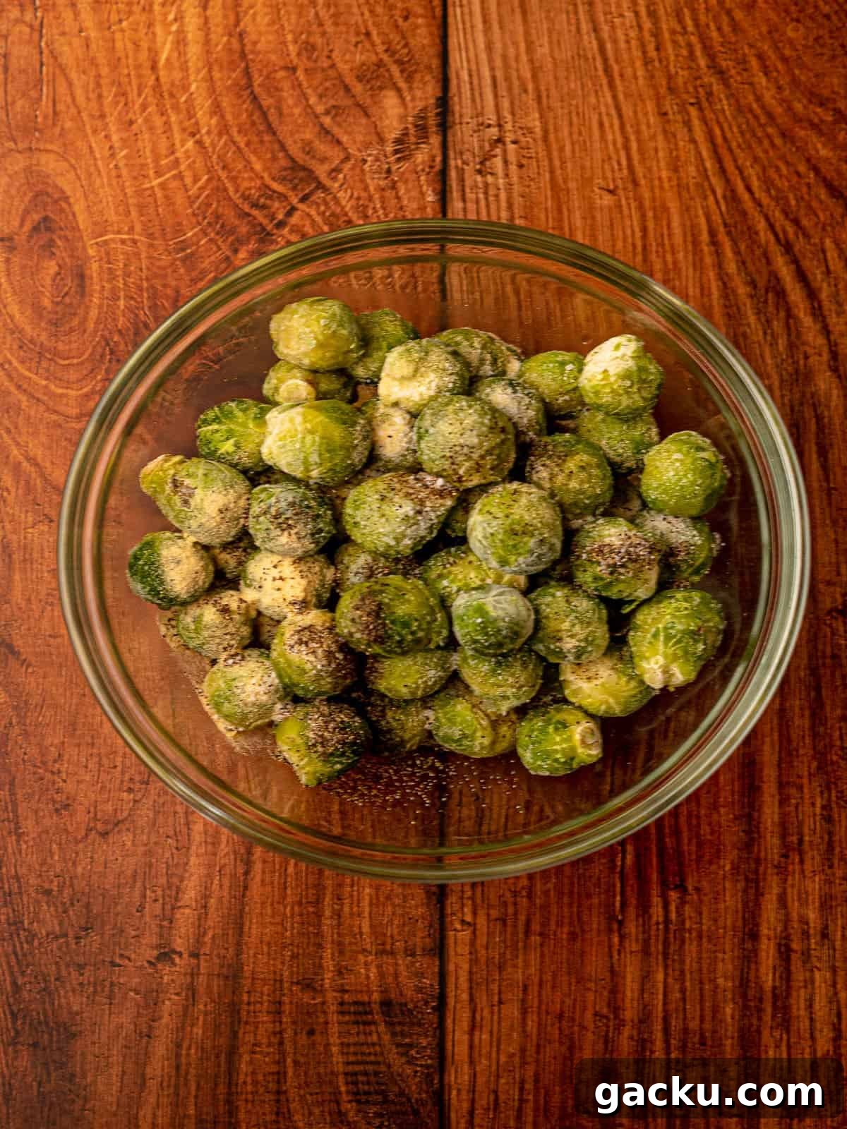 Crispy Air Fryer Frozen Brussels Sprouts Recipe 4 Frozen brussels in a bowl with seasonings.