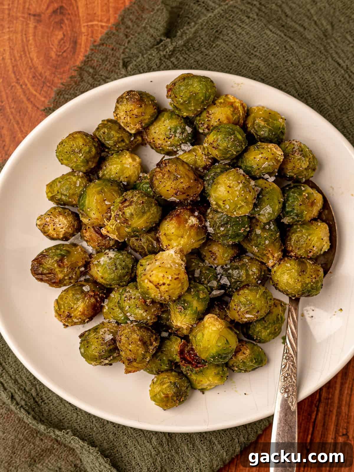Crispy Air Fryer Frozen Brussels Sprouts Recipe 6 A plate of brussels sprouts with a serving spoon.