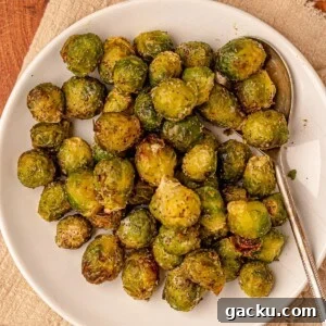 Crispy Air Fryer Frozen Brussels Sprouts Recipe 7 Brussels sprouts with a serving spoon on a plate.